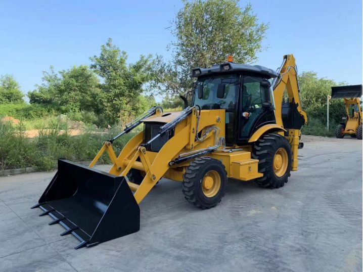 Tractopelle T75 4x4 chargeuse pelleteuse jaune sur chantier, godet avant et bras excavateur arrière